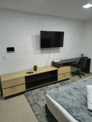 a bedroom with a desk and a television on a wall at Acogedor aparta-loft con jacuzzi in Medellín