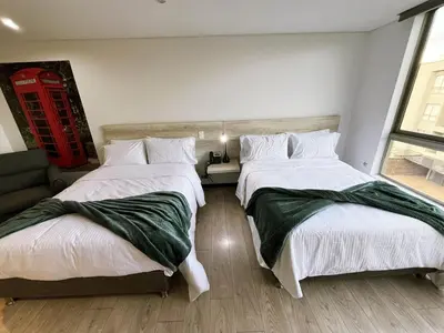 two beds in a room with a red phone booth at Private 1BR 2Bed AC Suite | Llanogrande Airport in Rionegro