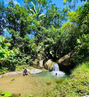 two people in a pool of water near a waterfall at Casa de campo Happy Hill in Cocorná