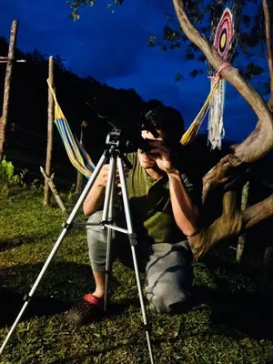 a man sitting in a chair next to a camera at Casa de campo Happy Hill in Cocorná