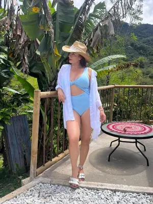a woman in a bikini and a hat standing next to a table at Casa de campo Happy Hill in Cocorná