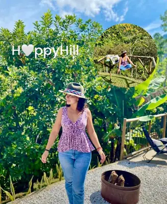 a woman walking through a garden with a person in a swing at Casa de campo Happy Hill in Cocorná