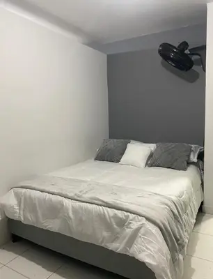 a bedroom with a large bed with a white bedspread at Apartamentos SAN LUIS in San Luis