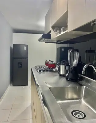 a kitchen with a sink and a refrigerator at Apartamentos SAN LUIS in San Luis