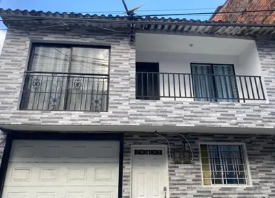 a brick house with two garage doors and a balcony at Apartamentos SAN LUIS in San Luis