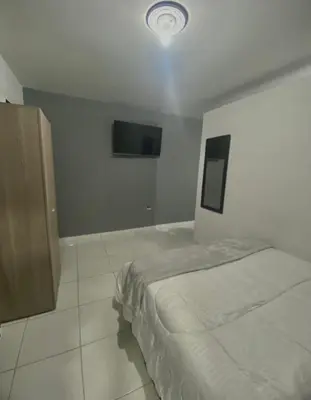 a bedroom with a bed and a tv on the wall at Apartamentos SAN LUIS in San Luis