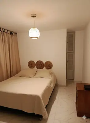 a bedroom with a bed and a chandelier at Oasis in Manila - El Poblado Estilo y Comfort in Medellín