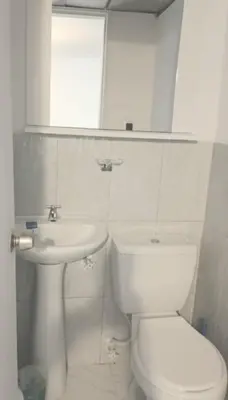 a white bathroom with a toilet and a sink at Oasis in Manila - El Poblado Estilo y Comfort in Medellín