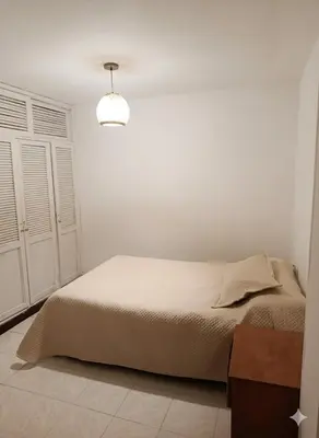 a white bedroom with a bed and a light at Oasis in Manila - El Poblado Estilo y Comfort in Medellín