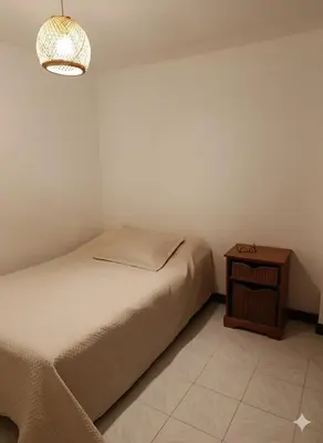 a bedroom with a bed and a night stand with a lamp at Oasis in Manila - El Poblado Estilo y Comfort in Medellín
