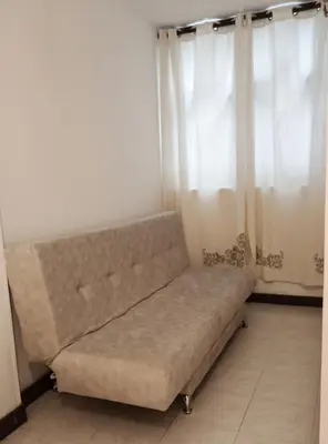 a couch sitting in a room with curtains at Oasis in Manila - El Poblado Estilo y Comfort in Medellín