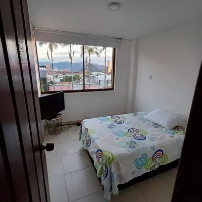a bedroom with a bed and a window at Apartamento Con Vista Hacia La Avenida Santander Y La Ciudad in Manizales