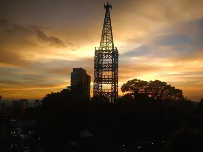a silhouette of a tower in a city at sunset at Apartamento Con Vista Hacia La Avenida Santander Y La Ciudad in Manizales