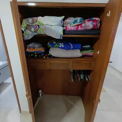 a wooden cabinet filled with lots of blankets and pillows at Apartamento Con Vista Hacia La Avenida Santander Y La Ciudad in Manizales