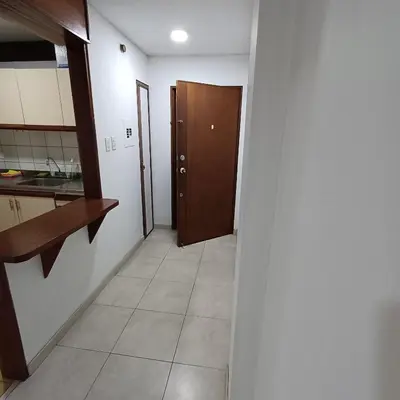 a hallway of a kitchen with a door and a tile floor at Apartamento Con Vista Hacia La Avenida Santander Y La Ciudad in Manizales