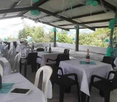 a banquet hall with white tables and chairs and bottles of wine at Ecohotel Los Cedros in Cocorná