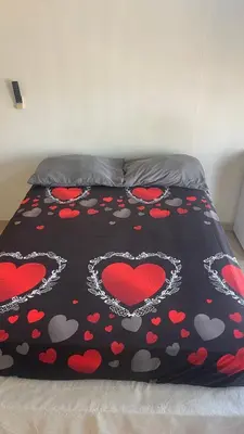 a bed with a black blanket with hearts on it at hotel morichal in Puerto Boyacá