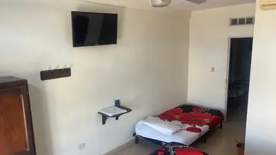 a room with a bed and a tv on the wall at hotel morichal in Puerto Boyacá