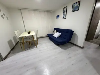 a living room with a blue couch and a table at Cómodo Apartamento - Estrato 5 in Manizales