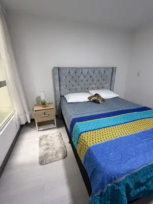 a bedroom with a bed with a blue comforter at Cómodo Apartamento - Estrato 5 in Manizales