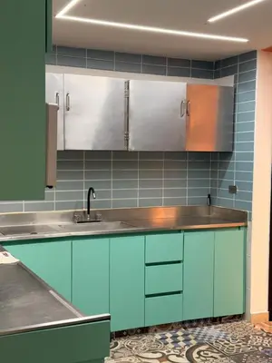 a kitchen with blue cabinets and a sink at Hostal Pacifico Encanto in Medellín