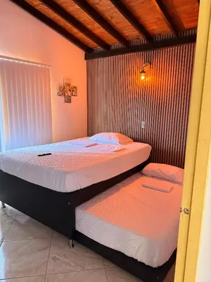 two twin beds in a room with at Hostal Pacifico Encanto in Medellín