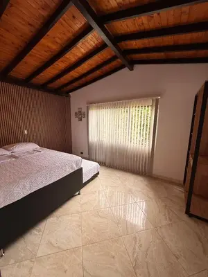 a bedroom with a bed and a large window at Hostal Pacifico Encanto in Medellín