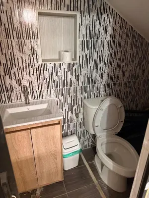 a bathroom with a toilet and a sink and a mirror at Hostal Pacifico Encanto in Medellín