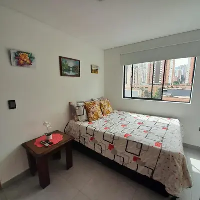 a bedroom with a bed and a table and a window at Acogedor Apartamento en Sabaneta in Sabaneta