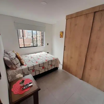 a bedroom with a bed and a table and a window at Acogedor Apartamento en Sabaneta in Sabaneta