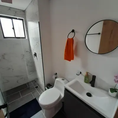 a bathroom with a toilet and a sink and a mirror at Acogedor Apartamento en Sabaneta in Sabaneta