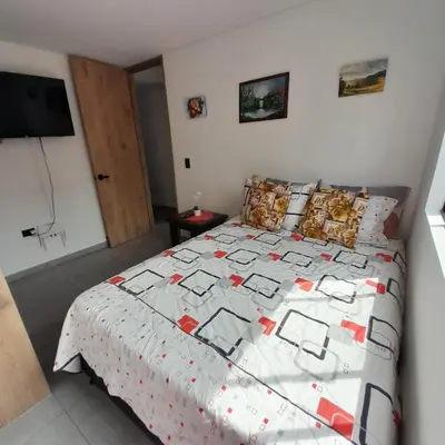 a bedroom with a bed with a quilt on it at Acogedor Apartamento en Sabaneta in Sabaneta