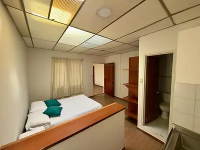 a bedroom with a bed with a green pillow on it at Apartamento en el centro de Manizales in Manizales