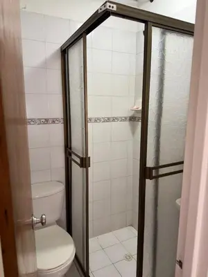a bathroom with a toilet and a glass shower at Apartamento en el centro de Manizales in Manizales