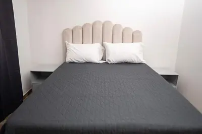 a bed with two pillows on top of it at Very spacious house one block from the park in San Luis