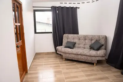 a living room with a couch and a window at Very spacious house one block from the park in San Luis