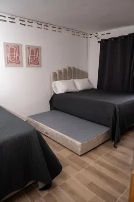 two beds in a room with black and white at Very spacious house one block from the park in San Luis