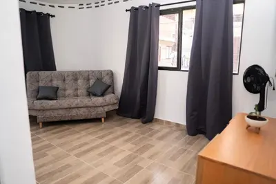 a living room with a couch and black curtains at Very spacious house one block from the park in San Luis