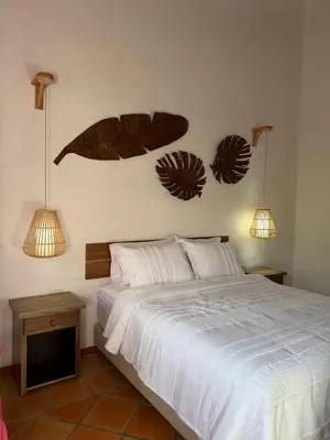 a bedroom with a bed and two lights on the wall at La juana cerro tusa in Venecia