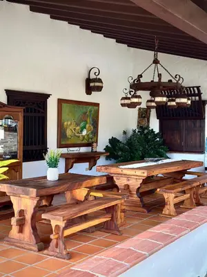 a patio with wooden picnic tables and a chandelier at La juana cerro tusa in Venecia