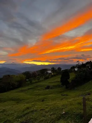 a sunset on a hill with a green field at La juana cerro tusa in Venecia