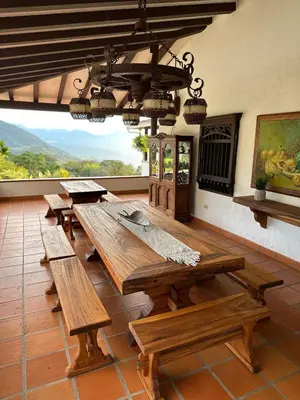 a large dining room with wooden tables and a chandelier at La juana cerro tusa in Venecia