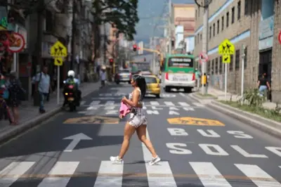 a woman crossing the street in a crosswalk at Family accommodation in downtown Itagüí in Itagüí