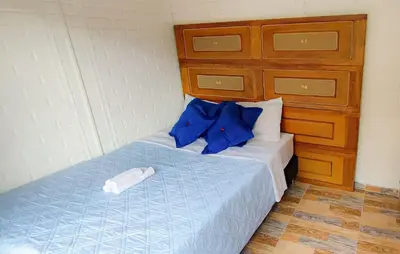 a bedroom with a bed with blue sheets and blue pillows at Family accommodation in downtown Itagüí in Itagüí