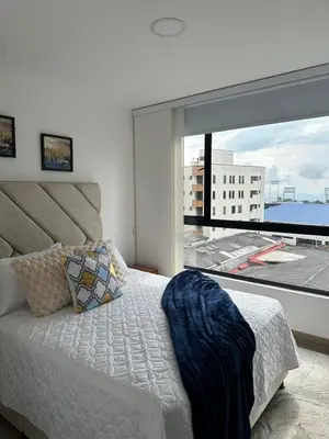 a bedroom with a bed and a large window at apartaestudios completos in Manizales