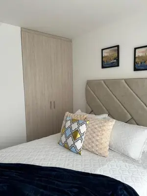 a bed with a headboard and a pillow on it at apartaestudios completos in Manizales