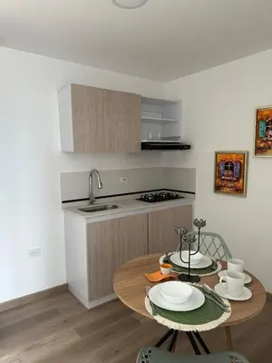 a kitchen with a wooden table and a kitchen with a sink at apartaestudios completos in Manizales