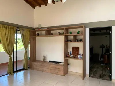 a living room with wooden shelves and a television at Finca coraline in Guarne