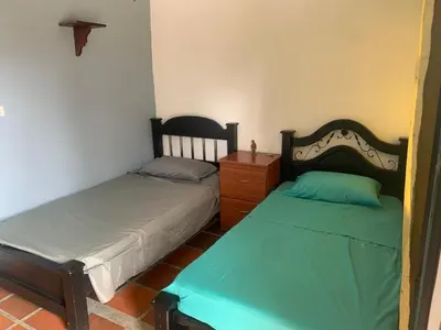 a bedroom with two beds and a dresser in it at Finca coraline in Guarne