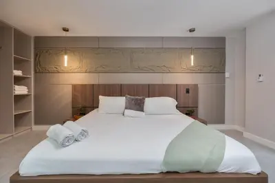 a bedroom with a large white bed with two pillows at Amazing apartment with Private Luxury Sauna Jacuzzi Steam Room Pool Table in Medellín